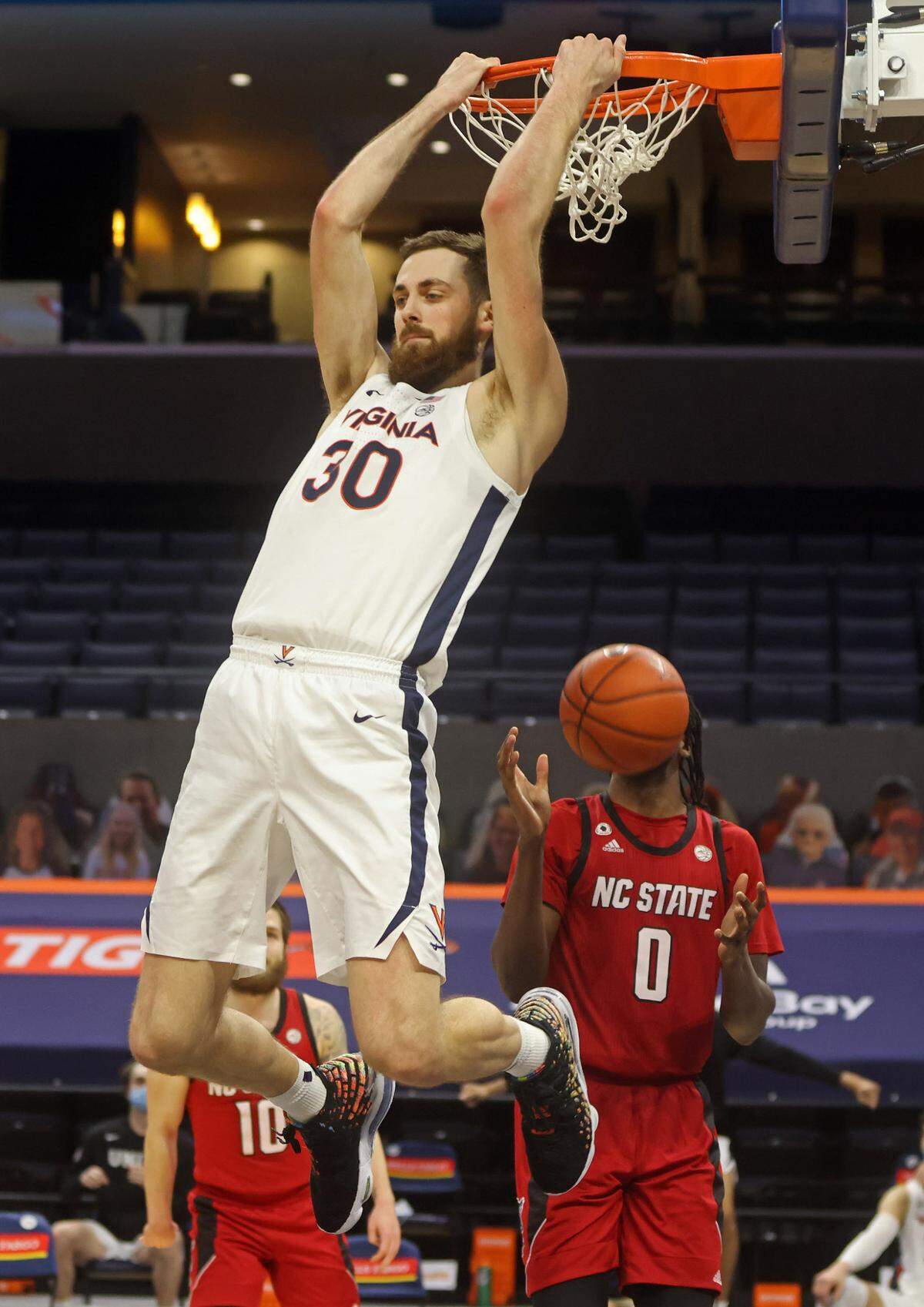 Virginia forward Jay Huff (30) dunks the ball next to North Carolina State forward DJ Funderburk (0) during the game Wednesday in Charlottesville, Va. North Carolina State defeated Virginia 68-61.