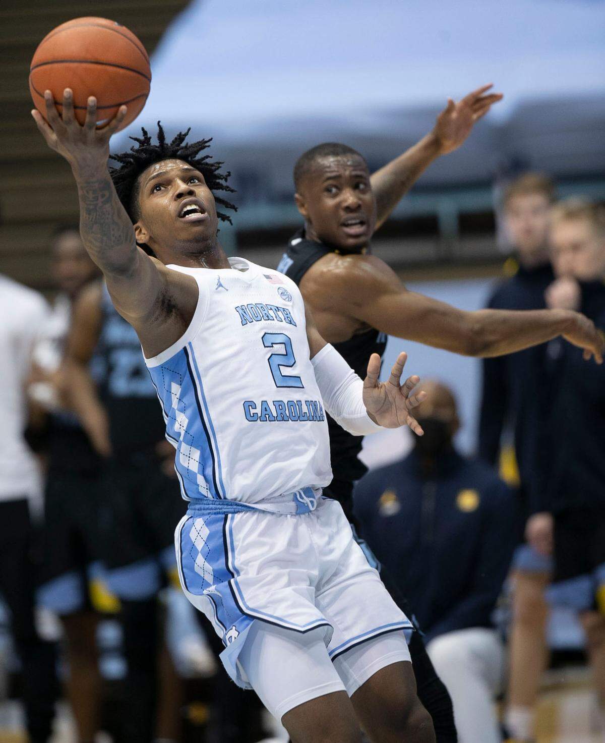 North Carolina’s Caleb Love (2) drives basket to the basket past Marquette’s Koby McEwen (25) during the first half on Wednesday, February 24, 2021 at the Smith Center in Chapel Hill, N.C.