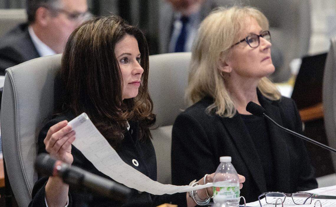 Kim Westbrook Strach, executive director of the Bipartisan State Board of Elections & Ethics Enforcement, left, unfurls early voting tabulations, during the second day of a public evidentiary hearing on the 9th Congressional District voting irregularities investigation Tuesday, Feb. 19, 2019, at the North Carolina State Bar in Raleigh.