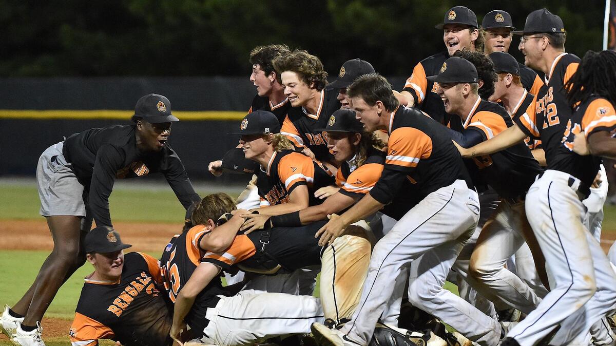 The Fuquay-Varina Bengals rush the field for the dogpile in celebration of their 4A baseball championship victory over Ronald Reagan. The Fuquay-Varina Bengals and the Ronald Reagan Raiders met in the NCHSAA 4A baseball final Series in Burlington NC on June 26, 2021.