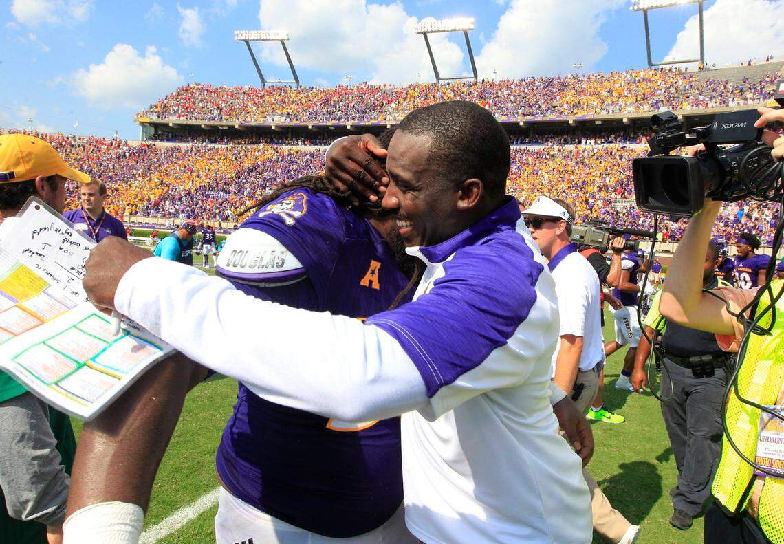 East Carolina head coach Scottie Montgomery celebrates with defensive lineman Demetri McGill (56) after ECU’s 33-30 victory over the Wolfpack in Greenville in 2016.