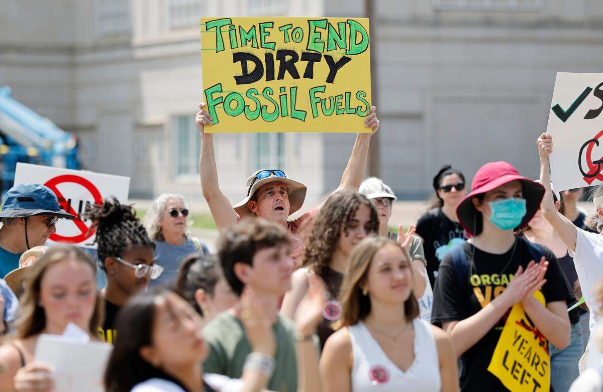 Sean Ross cheers on a speaker during a rally and march organized by NC WARN near the N.C. Executive Mansion in Raleigh Saturday.