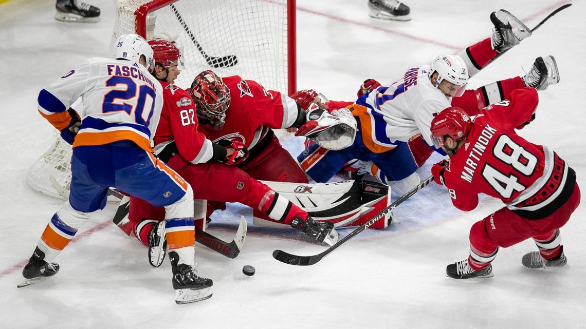 The Carolina Hurricanes Jesperi Kotkaniemi (82) and Jordan Martinook (48) work to clear the puck after a stop by goalie Antii Raanta (32) in the second period against the New York Islanders during Game 5 of their Stanley Cup series on Tuesday, April 25, 2023 at PNC Arena in Raleigh, N.C.