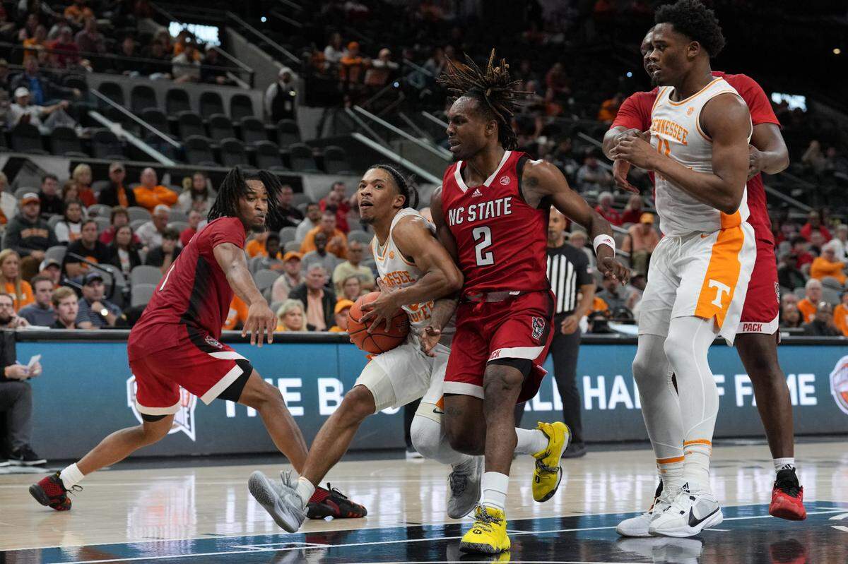 Dec 16, 2023; San Antonio, Texas, USA; Tennessee Volunteers guard Zakai Zeigler (5) drives in against North Carolina State Wolfpack guard Kam Woods (2) in the second half at the Frost Bank Center. Mandatory Credit: Daniel Dunn-USA TODAY Sports