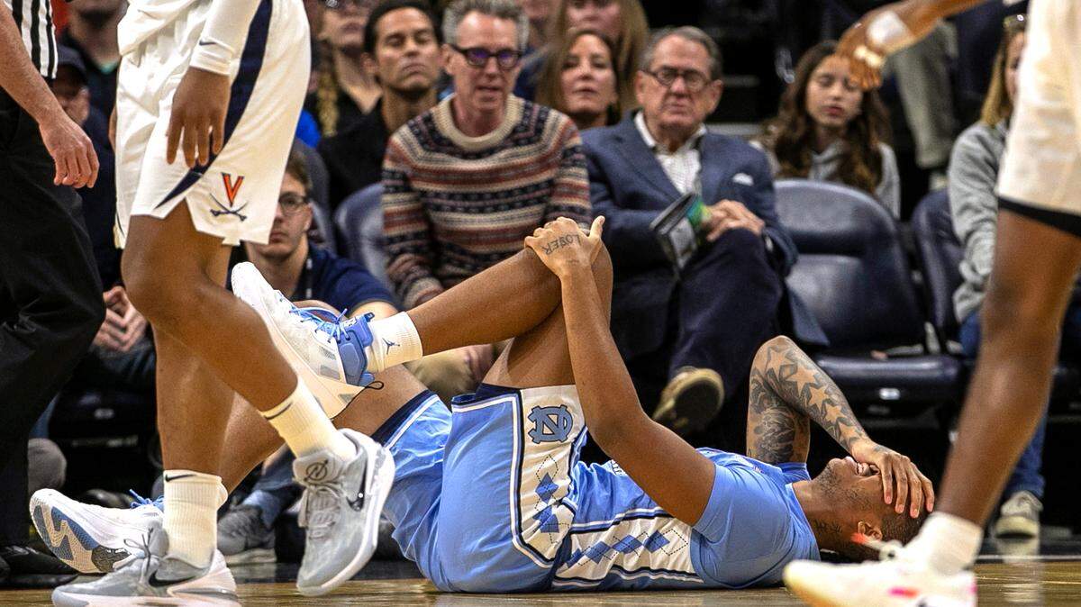 North Carolina’s Armando Bacot (5) grimaces in pain after injuring his left ankle in the opening minutes of play against Virginia on Tuesday, January 10, 2023 at John Paul Jones Arena in Charlottesville, Va.