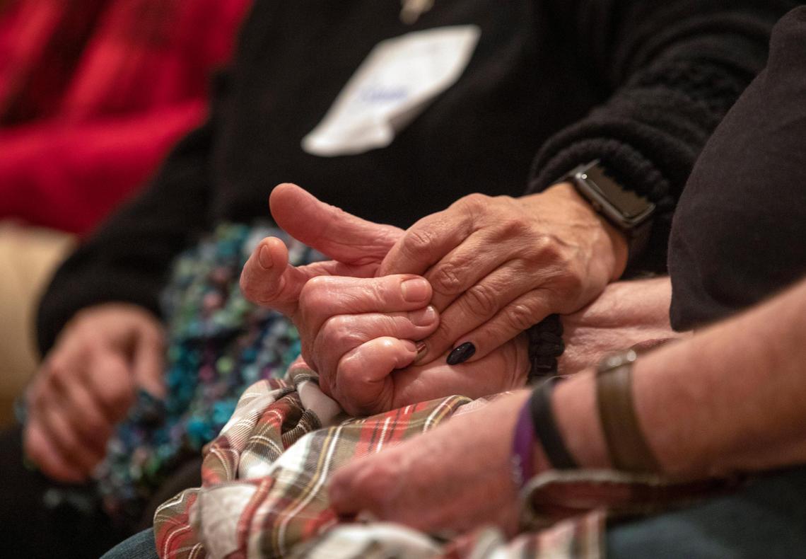 A patient and a caregiver hold hands during a monthly support group that meets at the Nasher Museum of Art, called ‘Reflections’, organized by the Duke Dementia Family Support Program, designed for both patients and caregivers to engage with works of art together while building a sense of community, on Wednesday, Jan. 8, 2020, in Durham, N.C.