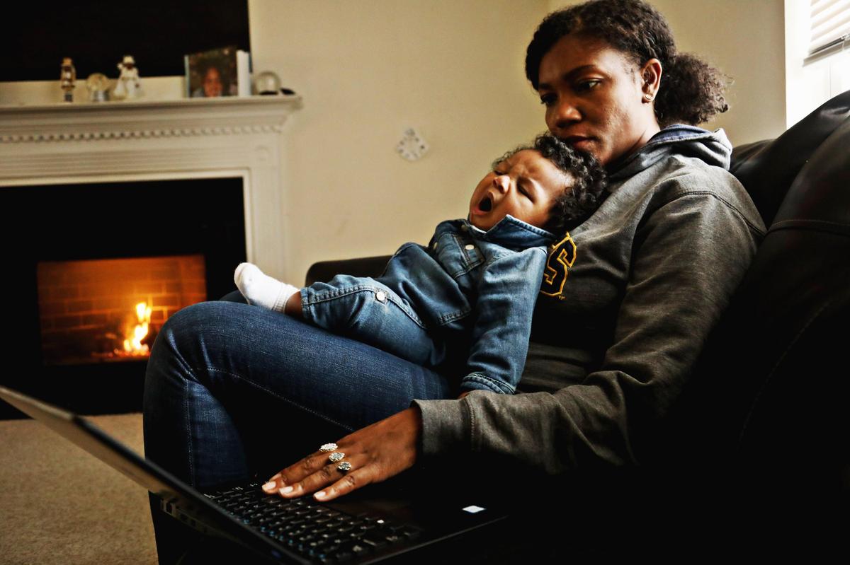Richard yawns in mom Jessica Murrell Berryman’s lap as she works remotely from the family’s Durham home Dec. 6, 2019. Berryman enrolled in Medicaid for a short time when she had her first child right after college.