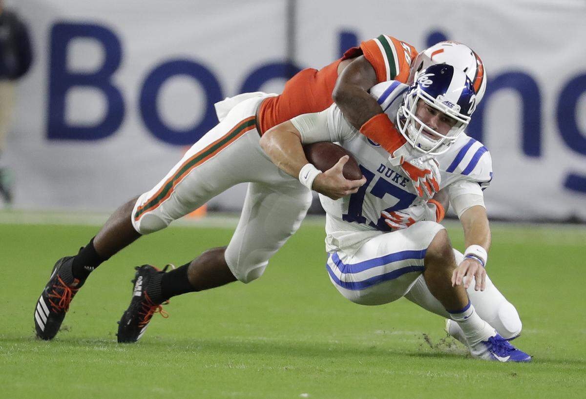 Duke quarterback Daniel Jones (17) is tackled by Miami linebacker Michael Pinckney during the first half.