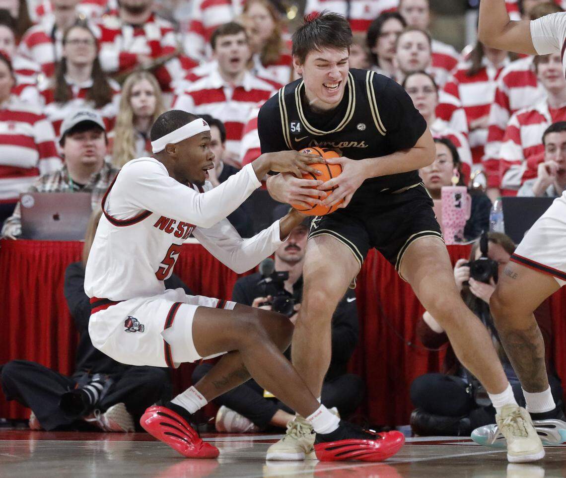 N.C. State’s Tre Holloman battles for possession with Wake Forest’s Cooper Schwieger during the second half of the Wolfpack’s 70-57 win on Wednesday, Dec. 31, 2025, at Lenovo Center in Raleigh, N.C.