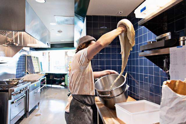 Baker Joshua Bellamy pulls dough from the mixer to prep donuts on Friday, March 18, 2022, at the new Raleigh bakery, Bright Spot Donuts, which will open soon near the Five Points Neighborhood.