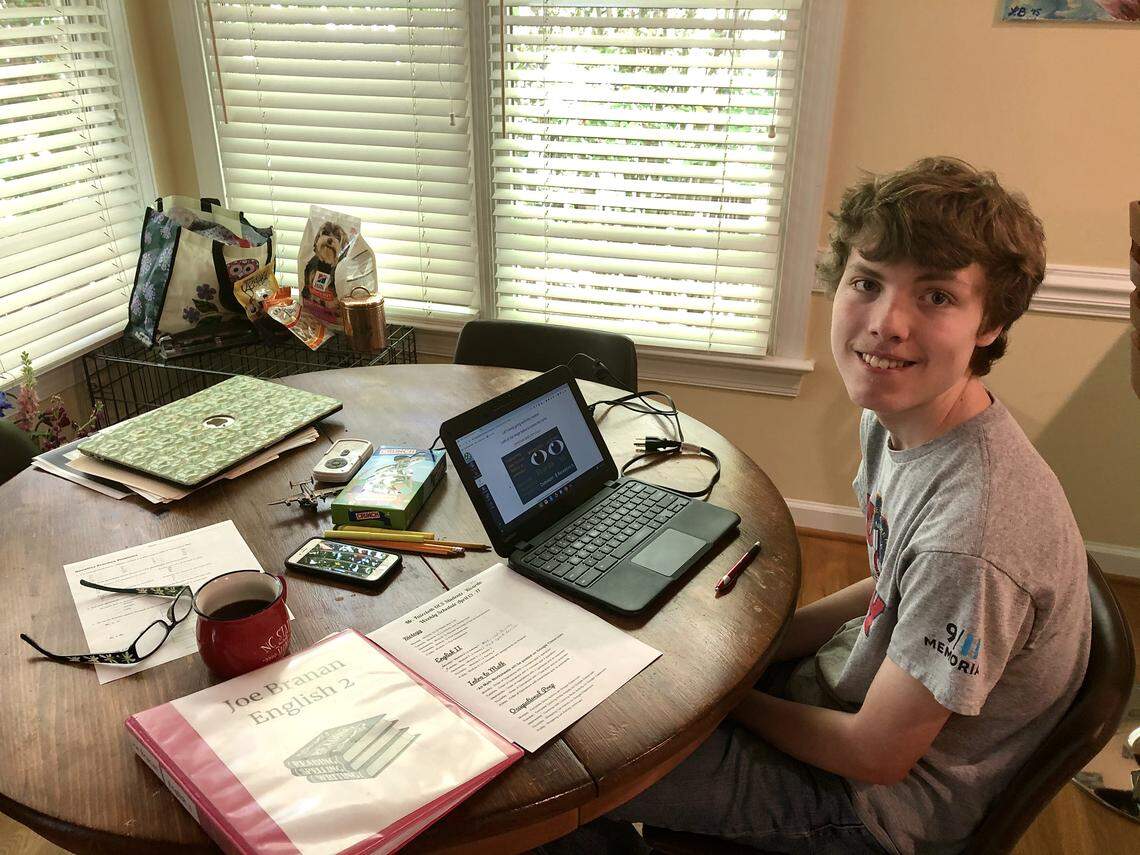 Joe Branan, 18, sits at his family’s kitchen table doing his Biology school work on Tuesday morning, April 14. Joe has Autism and is adapting to working from home, with the help of his mother Laura and his teachers at Carrboro High School.