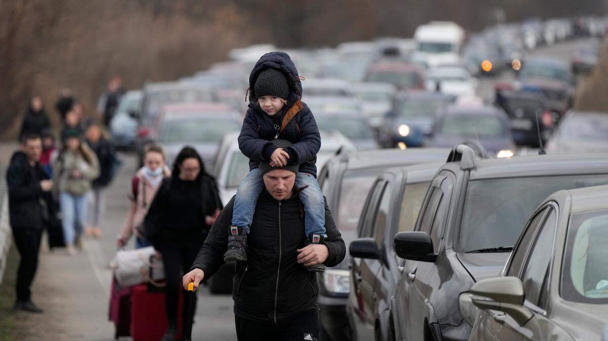 Ukrainian refugees walk along vehicles lining-up to cross the border from Ukraine into Moldova just after the Russian invasion of Ukraine began in February. Moldova and North Carolina have a special relationship going back more than two decades.