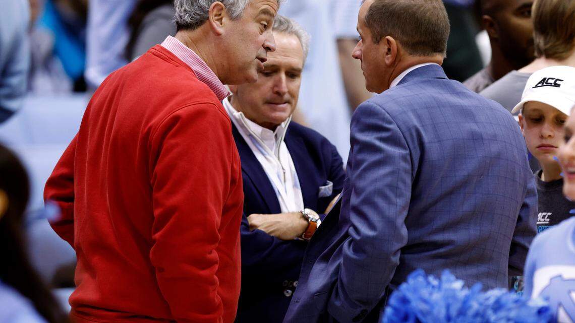 N.C. State athletic director Boo Corrigan, left, and North Carolina athletic director Bubba Cunningham, center, talk with ACC Commissioner Jim Phillips before N.C. State’s game against UNC at the Smith Center in Chapel Hill, N.C., on Jan. 21, 2023.