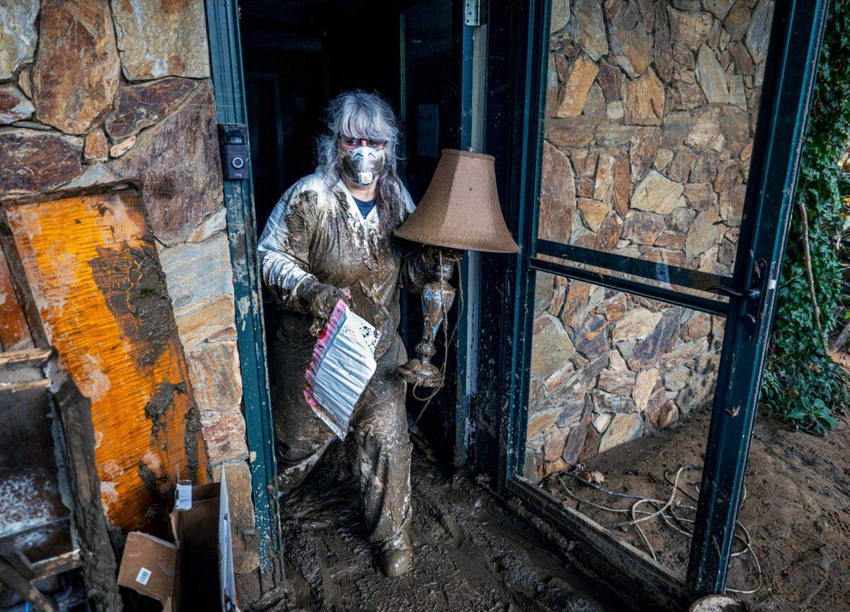 Susan Figetakis recovers items from her home, flooded by Hurricane Helene, along Green River Cove Road on Monday, October 7, 2024, near Saluda, N.C
