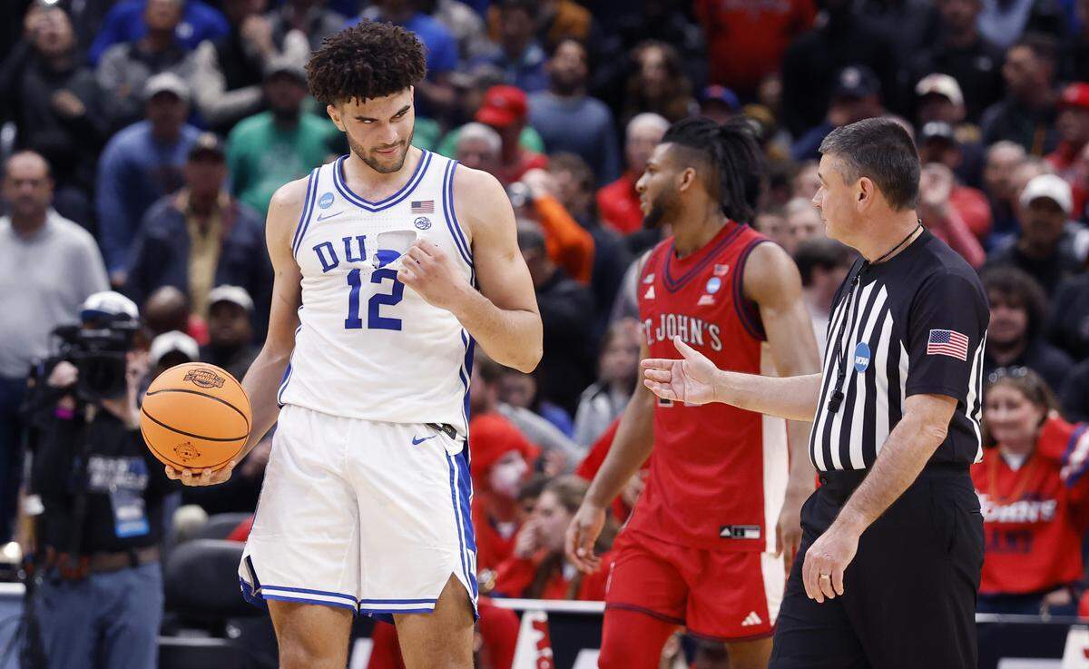 Duke’s Cameron Boozer (12) shows off his torn jersey to official Pat Driscoll during the second half of Duke’s 80-75 victory over St. John’s in the Sweet 16 of the NCAA Men’s Basketball East Regional at Capital One Arena in Washington, D.C., Friday, March 27, 2026.