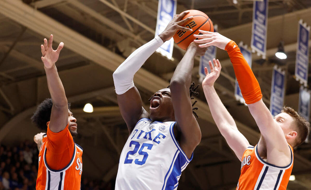 Duke’s Mark Mitchell (25) drives to the basket between Syracuse’s Kyle Cuffe Jr. (0), left, and Justin Taylor (5) during the first half of Duke’s game against Syracuse at Cameron Indoor Stadium in Durham, N.C., Tuesday, Jan. 2, 2024.
