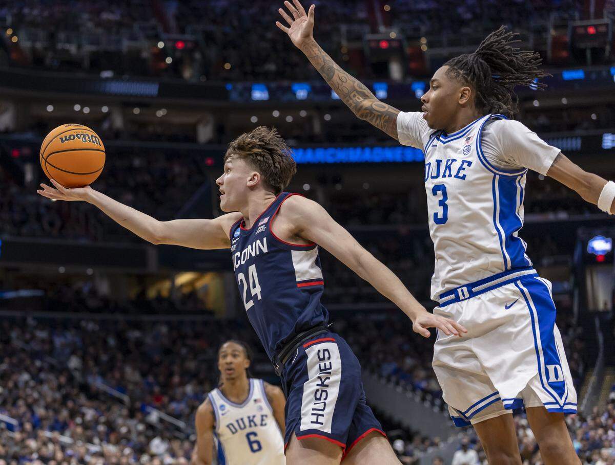 Connecticut guard Braylon Mullins (24) breaks to the basket against Duke forward Isaiah Evans (3) in the second half on Sunday, March 29, 2026, in the NCAA East Regional Championship, at Capital One Arena in Washington, 