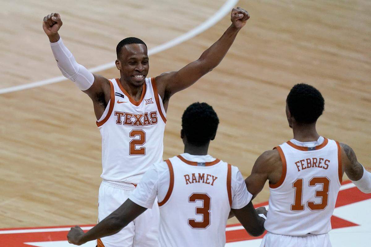 Texas’ Matt Coleman III, center, celebrates with Courtney Ramey (3) and Jase Febres (13) after the team’s win over Oklahoma State inthe championship of the Big 12 men’s tournament in Kansas City, Mo, Saturday, March 13, 2021.