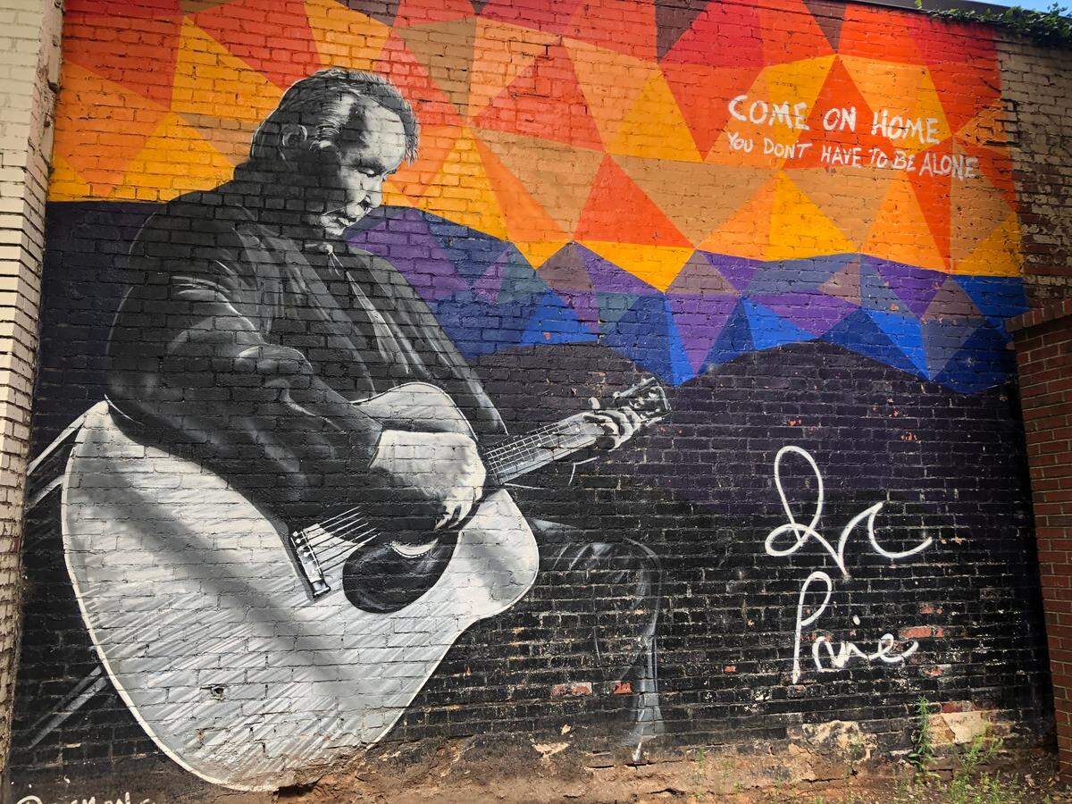 The John Prine Memorial at 107 E Martin St by Scott Nurkin, was created to promote Prine’s Grammy award.