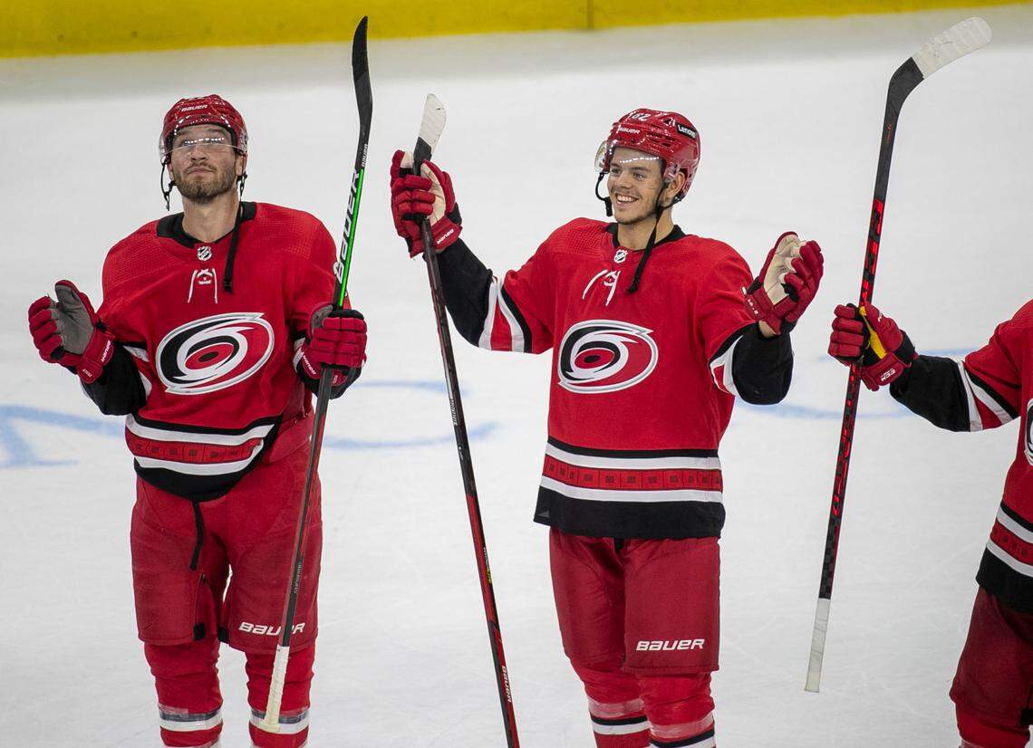 Carolina Hurricanes Brett Pesce (22) and Jesperi Kotkaniemi (82) celebrate their 6-3 victory over the New York Islanders on Thursday, October 14, 2021 at PNC Arena in Raleigh, N.C.