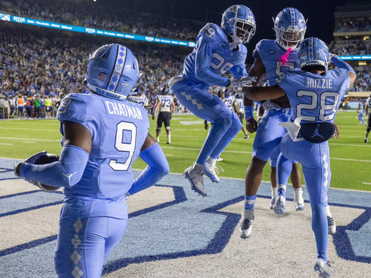 North Carolina’s Armani Chatman (9) Marcus Allen (29) Jahvaree Ritzie (5) and Alijah Huzzie (28) celebrate the Tar Heels’ 47-45 victory in double overtime on Saturday, Nov. 11, 2023 at Kenan Stadium in Chapel Hill, N.C. Huzzie broke up a two-point conversion that sealed the victory.