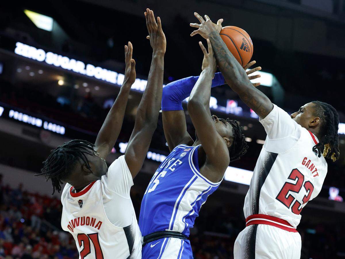N.C. State’s Greg Gantt (23) blocks the shot by Duke’s Mark Mitchell (25) as N.C. State’s Ebenezer Dowuona (21) also defends during the first half of N.C. State’s game against Duke at PNC Arena in Raleigh, N.C., Wednesday, Jan. 4, 2023.