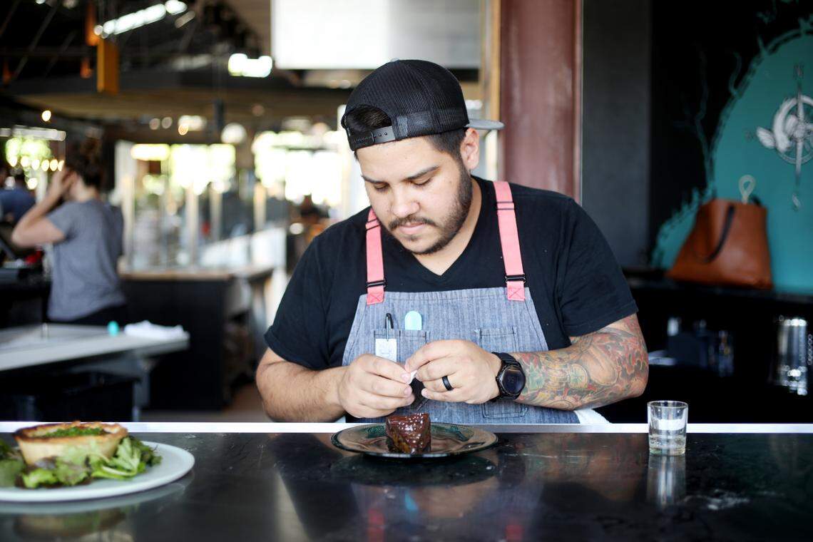 Chef Eric Montagne looks over the whey caramel tarte from the dessert menu at Locals Oyster Bar in Transfer Co. Food Hall in Raleigh on Thursday, Aug. 29, 2019.