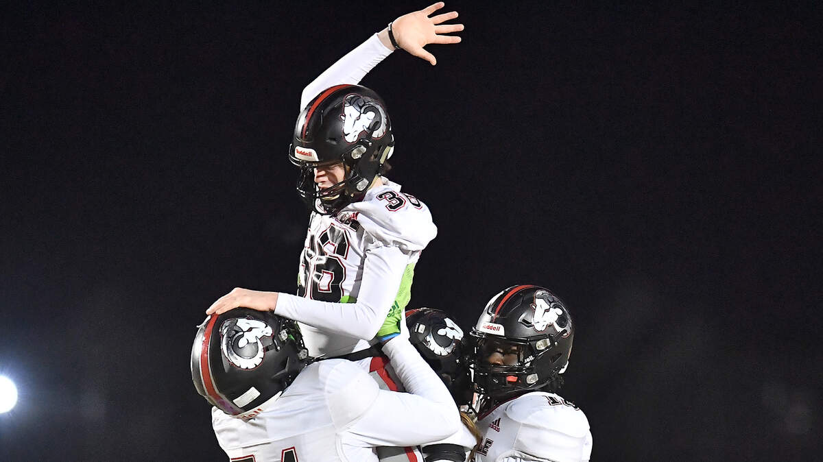 Rolesville’s Christian Turner (54) lifts up and celebrates with kicker Riley Daniels (36) after his long field goal against Rolesville during the second half. The Rolesville Rams and the Cleveland Rams met in the fourth round of the NCHSAA 4A football playoffs in Clayton, N.C. on December 6, 2024.