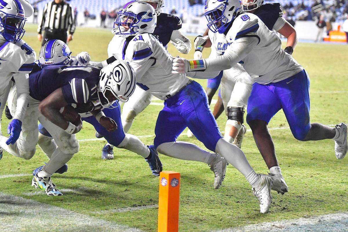 Grimsley quarterback Faizon Brandon (11) pushes for the goal line against defense from Clayton linebacker Christian Schmidt (11) during the second half.  The Clayton Comets and the Grimsley Whirlies met in the NCHSAA 7A football Championships in Chapel Hill, NC on December 12, 2025.