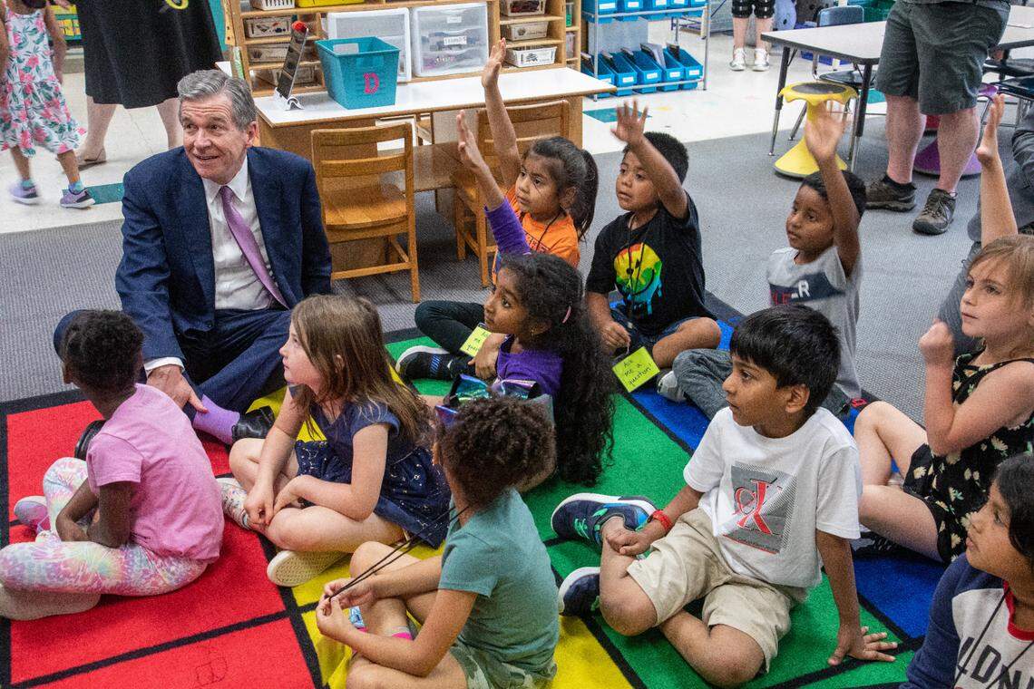 Gov. Roy Cooper visits a kindergarten class while touring Washington Magnet Elementary School in Raleigh Tuesday, May 23, 2023. Cooper says state lawmakers would ‘starve’ public education with universal private school vouchers, more tax cuts and small raises for veteran teachers.