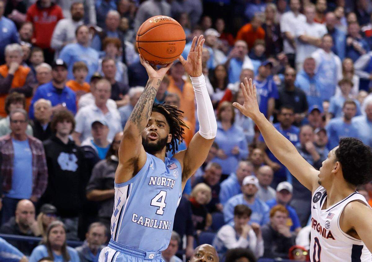 North Carolina’s RJ Davis (4) hits a three-pointer as Virginia’s Kihei Clark (0) defends during the first half of UNC’s game against Virginia in the quarterfinals of the ACC Men’s Basketball Tournament in Greensboro, N.C., Thursday, March 9, 2023.