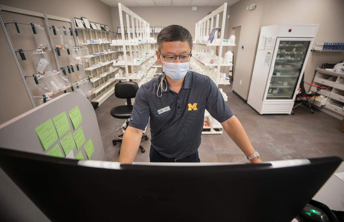Jin Lee, owner of DJ’s Pharmacy in Cary, N.C., works at his computer before leaving to volunteer with the Episcopal Farm Worker Ministry in Dunn, N.C. on Sept. 4, 2021. Lee volunteers on weekends with organizations that work with underserved communities to administer COVID-19 vaccines.