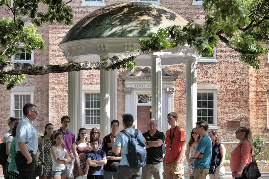 A tour group of parents, future students and family members learn the history of UNC’s Old Well on the Chapel Hill campus. Now, campuses have limited visitors due to coronavirus concerns. 