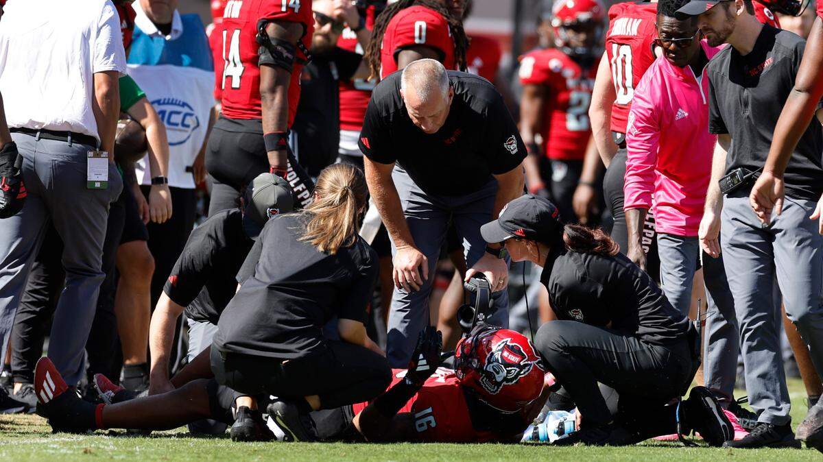 N.C. State head coach Dave Doeren checks on safety Rakeim Ashford (16) after he was injured during the first half of N.C. State’s game against Marshall at Carter-Finley Stadium in Raleigh, N.C., Saturday, Oct. 7, 2023.