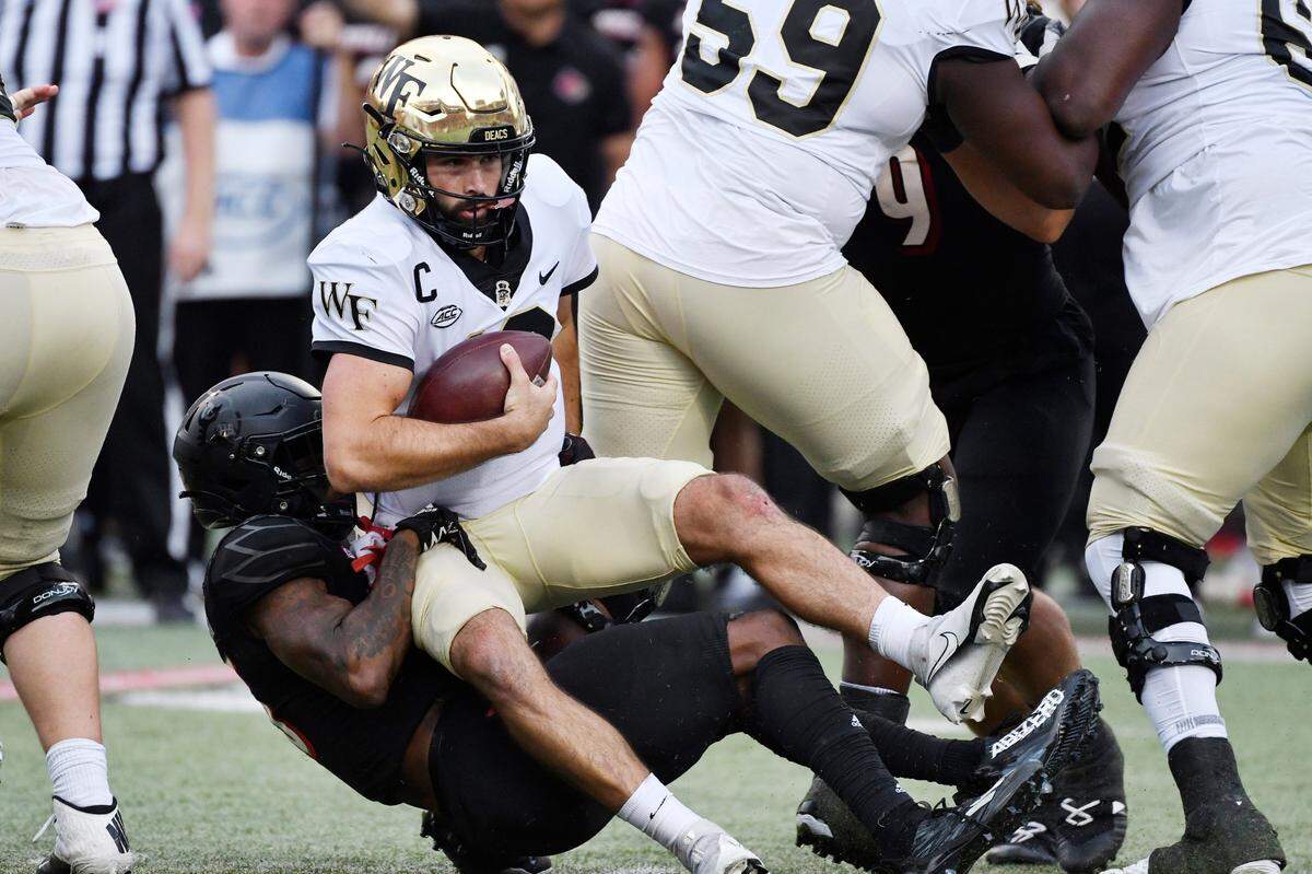 Wake Forest quarterback Sam Hartman (10) is sacked by Louisville defensive back Kei’Trel Clark (13) during the first half of an NCAA college football game in Louisville, Ky., Saturday, Oct. 29, 2022.