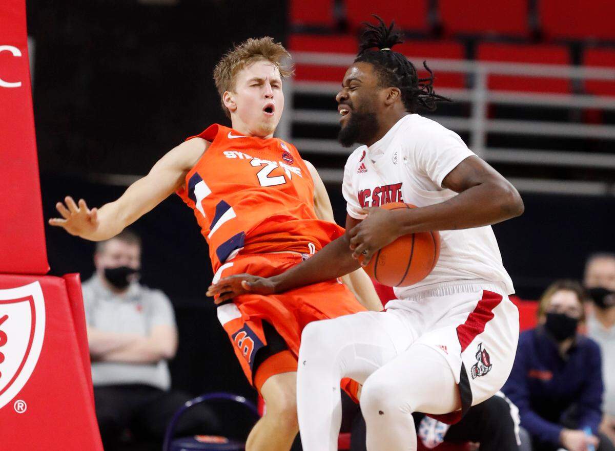 N.C. State’s D.J. Funderburk (0) is called for the foul after running into Syracuse’s Marek Dolezaj (21) during the first half of N.C. State’s game against Syracuse at PNC Arena in Raleigh, N.C., Tuesday, February 9, 2021.