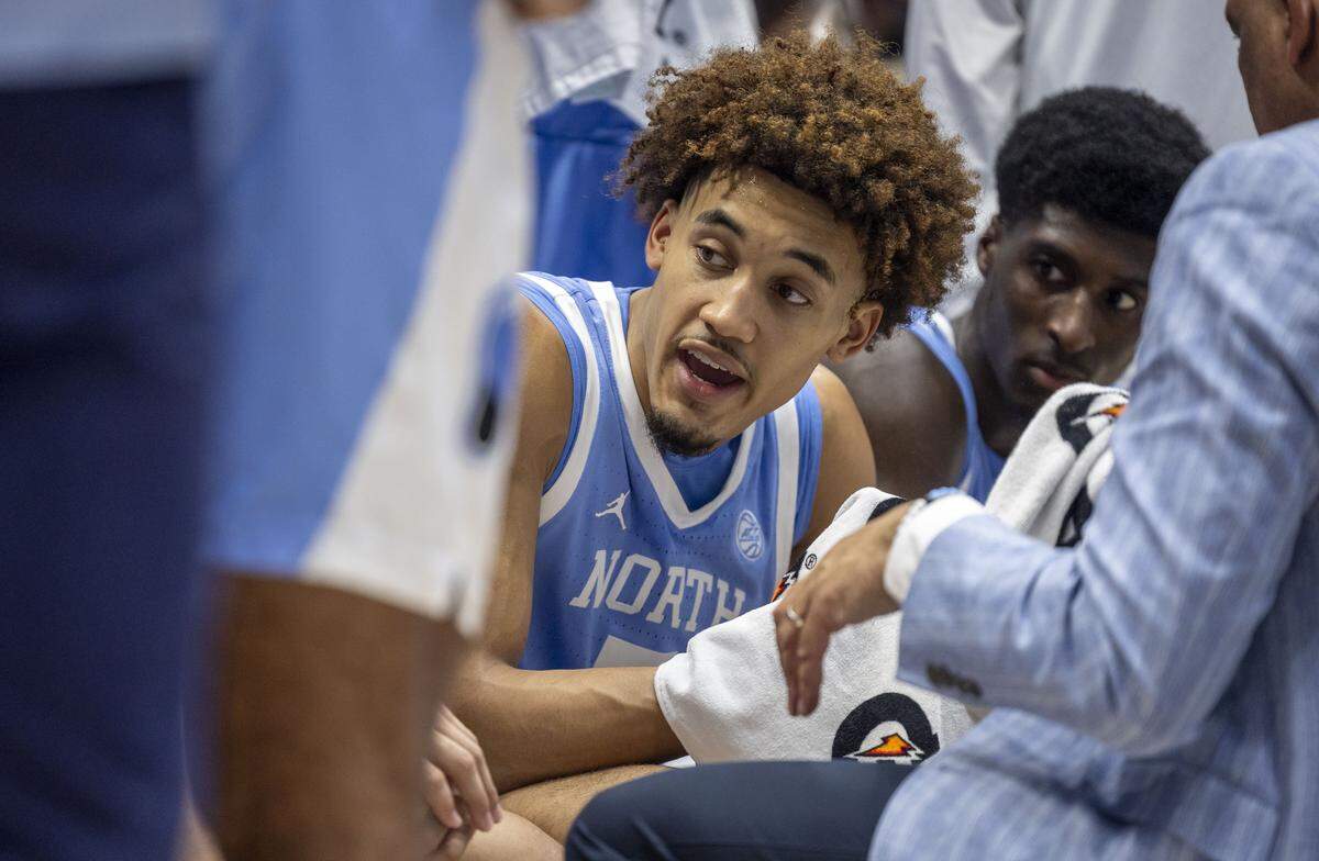 North Carolina guard Seth Trimble (7) talks with his teammates during a time-out huddle with coach Hubert Davis  in the second half against Duke on Saturday, February 1, 2025 at Cameron Indoor Stadium in Durham, N.C. 