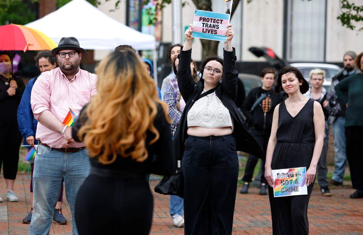 Theiry Wall, center left, and Anna Lee, right, listen to Naomi Dix during the Drag the Fascists rally at CCB Plaza in Durham, N.C., Saturday, April 1, 2023. The rally was to protest the anti-drag show bills being introduced in states across the country and celebrate Gay, Lesbian, Bisexual, Transgender, Queer, Intersex, and Asexual people.
