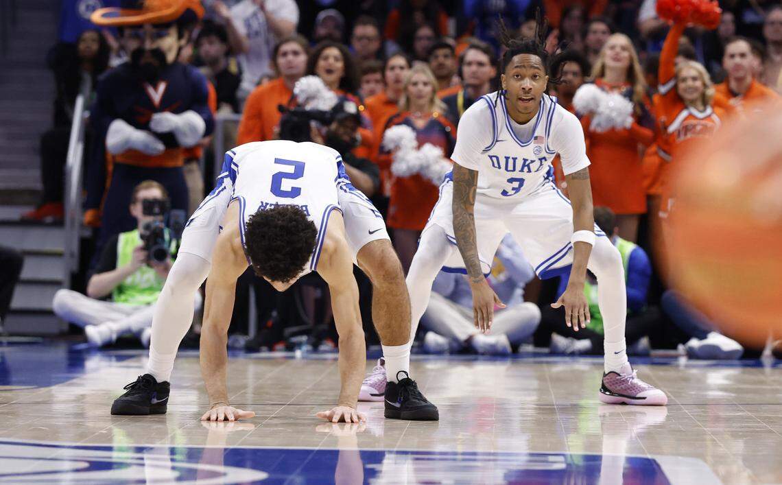 Duke’s Cayden Boozer (2) and Isaiah Evans (3) hit the floor late in the second half of Duke’s 74-70 victory over Virginia in the finals of the 2026 ACC Men’s Basketball Tournament at the Spectrum Center in Charlotte, N.C., Saturday, March 14, 2026.