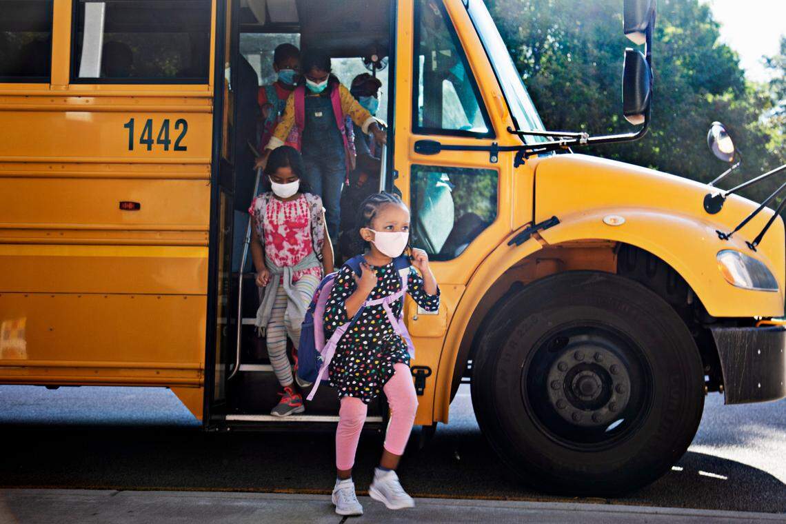 Students exit a school bus in Cary at the start of the 2021-22 school year. Starting March 7, face masks will no longer be required in Wake County school buses.