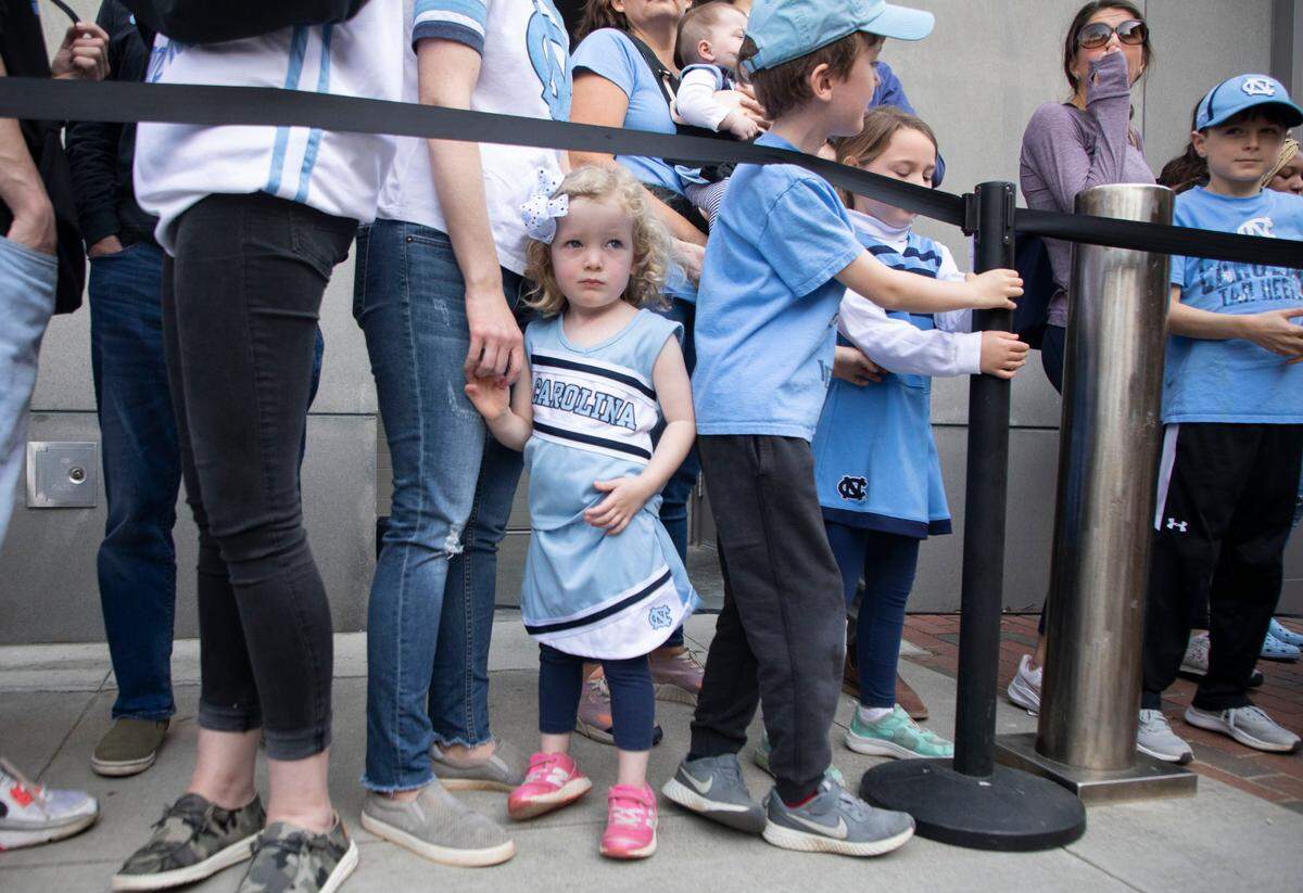 Caroline Wilson, 3, waits with her family for the UNC basketball team to walk to their bus outside the Dean Dome in Chapel Hill, N.C. to travel to New Orleans for the Final Four on Wednesday, March 30, 2022.