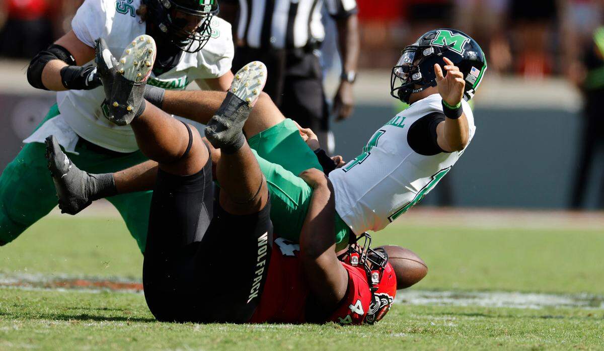 N.C. State defensive lineman Brandon Cleveland (44) sacks Marshall quarterback Cam Fancher (14) as he fumbles the ball during the first half of N.C. State’s game against Marshall at Carter-Finley Stadium in Raleigh, N.C., Saturday, Oct. 7, 2023.