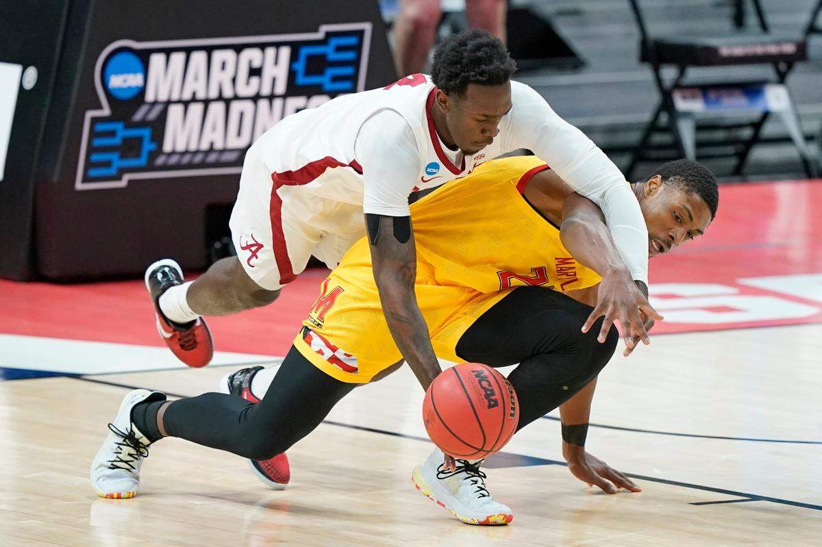 Alabama’s Juwan Gary, top, dives over Maryland’s Jairus Hamilton, bottom, to reach a loose ball during the first half of a college basketball game in the second round of the NCAA tournament at Bankers Life Fieldhouse in Indianapolis Monday, March 22, 2021. 