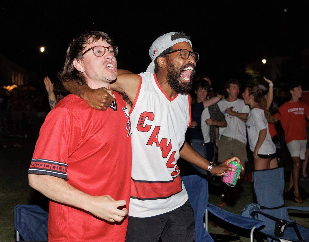 Derik Haggard and Jonathan Duren celebrate at a watch party in Moore Square after the Carolina Hurricanes tied Game 2 of the Stanley Cup Final at 2-2 in the third period on Thursday, June 4, 2026. 