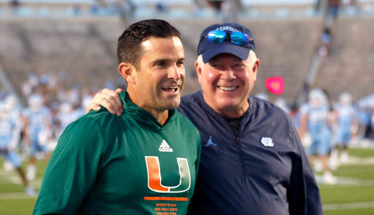 UNC head coach Mack Brown, right, talks with Miami head coach Manny Diaz before North Carolinas game against Miami at Kenan Stadium in Chapel Hill, N.C., Saturday, October 16, 2021.