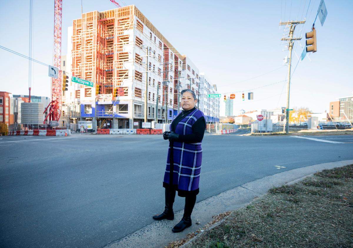 Anita Scott Neville stands surrounded by new construction at the intersection of East Pettigrew Street and Dillard Street in downtown Durham, N.C., on Nov. 27, 2021.