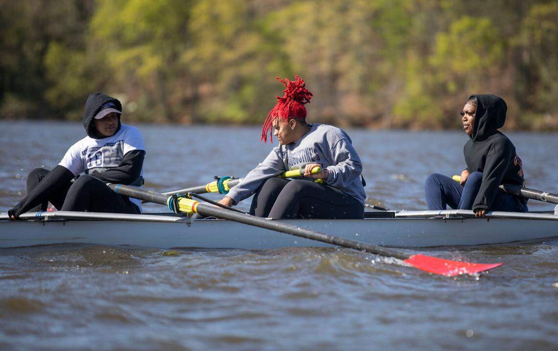 Destini “Dee” Vance, left, Mikahya Hill, middle, and Drea Taylor, right, all members of the first women’s crew team at Saint Augustine’s University, ride out to a cove on Raleigh’s Lake Wheeler during practice on Sunday, April 10, 2022.