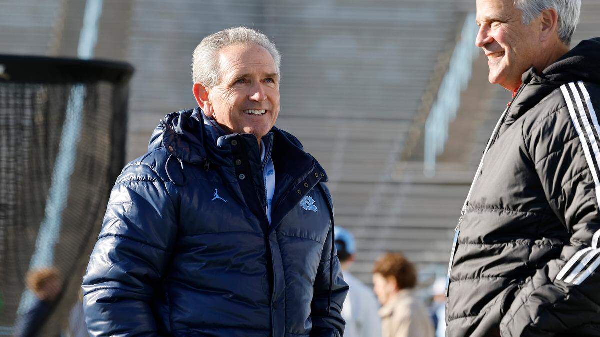 North Carolina athletic director Bubba Cunningham talks with N.C. State athletic director Boo Corrigan before N.C. State’s game against UNC at Kenan Stadium in Chapel Hill, N.C., Saturday, Nov. 30, 2024.