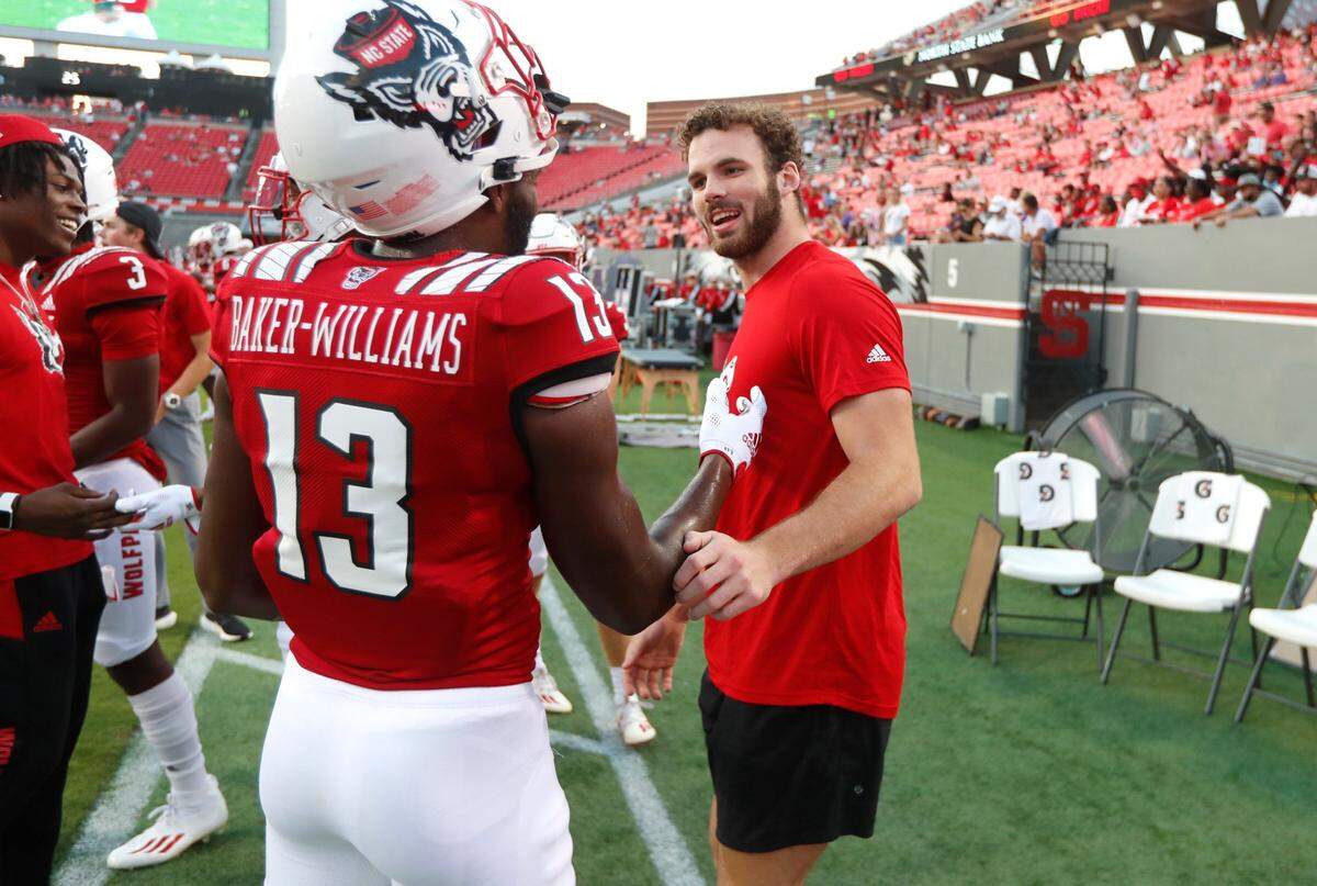N.C. State’s Payton Wilson, right, jokes with defensive back Tyler Baker-Williams (13) before the Wolfpack’s game against Furman in September 2021.