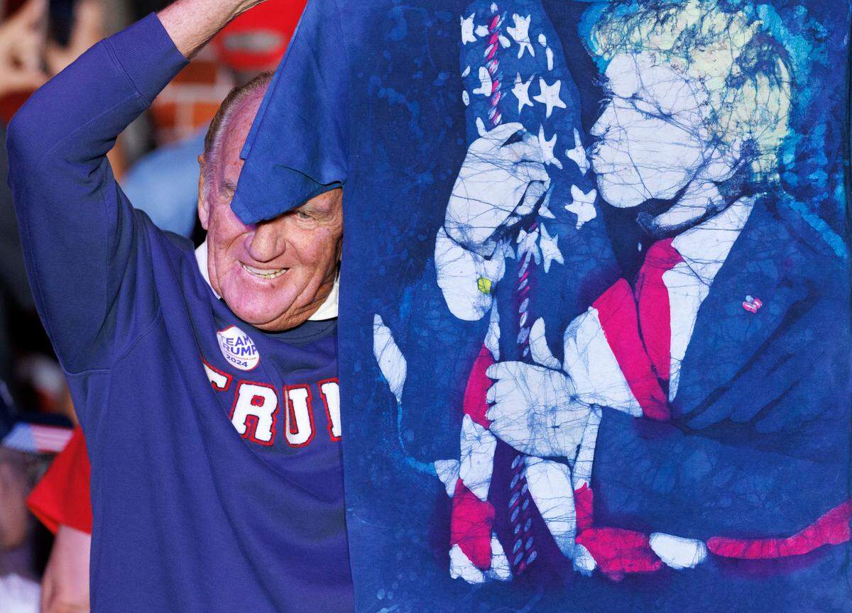 A supporter of former President and Republican presidential candidate Donald Trump holds up a shirt during a campaign rally at the Greensboro Coliseum Complex on Tuesday, Oct. 22, 2024, in Greensboro, N.C.